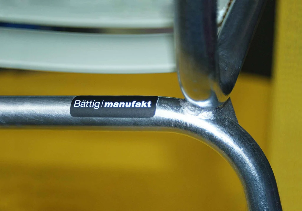 Bättig | manufakt Label auf dem Stahlrohr eines Gartenstuhls